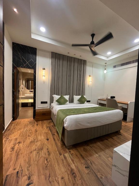 a hotel room with a bed and a ceiling fan at Red Leaf Hisar in Hisār