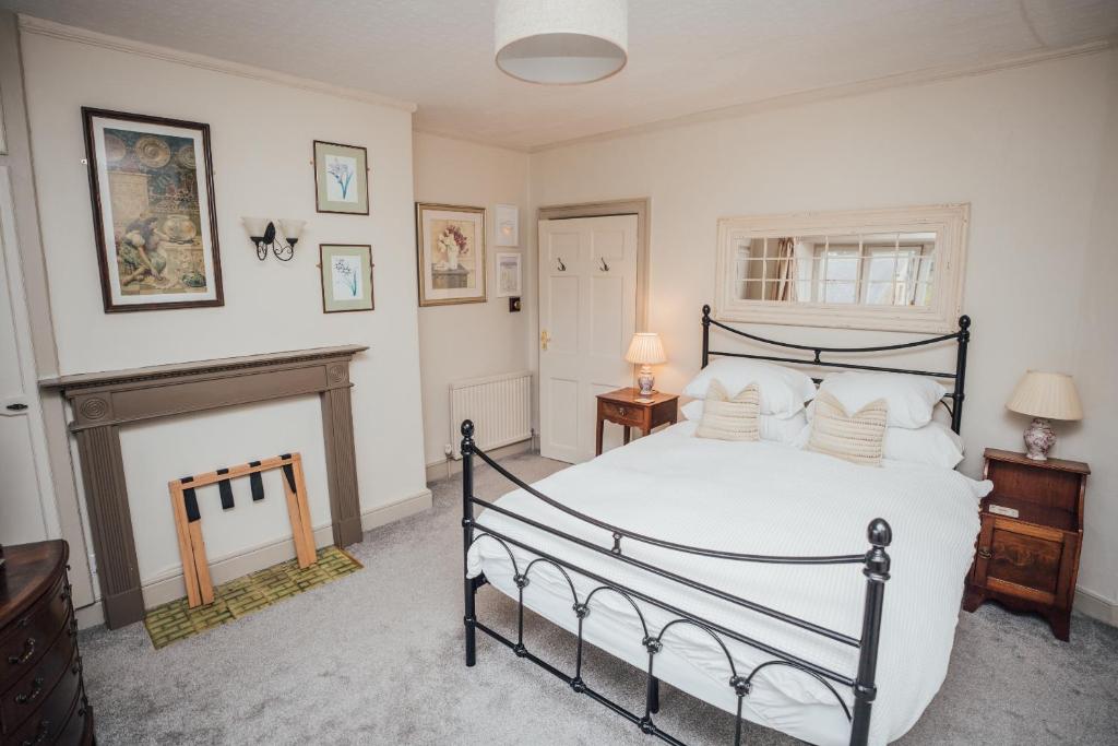 a bedroom with a large bed and a fireplace at Farthings Hotel and Restaurant in Taunton