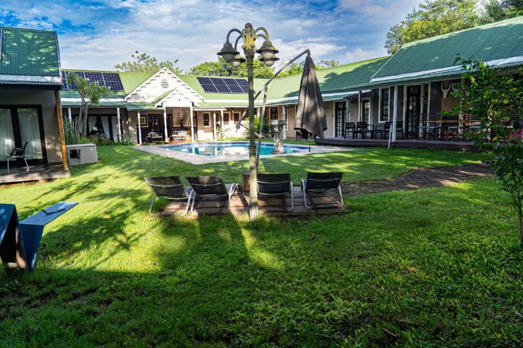 a resort with a yard with chairs and a pool at Cu Guest House in Phalaborwa
