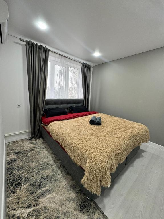 a bedroom with a large bed with a large window at Apartaments Briceni city in Briceni