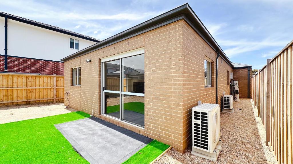 a brick house with a window and green grass at Westbrook 3B3B Home by GoodLive in Truganina