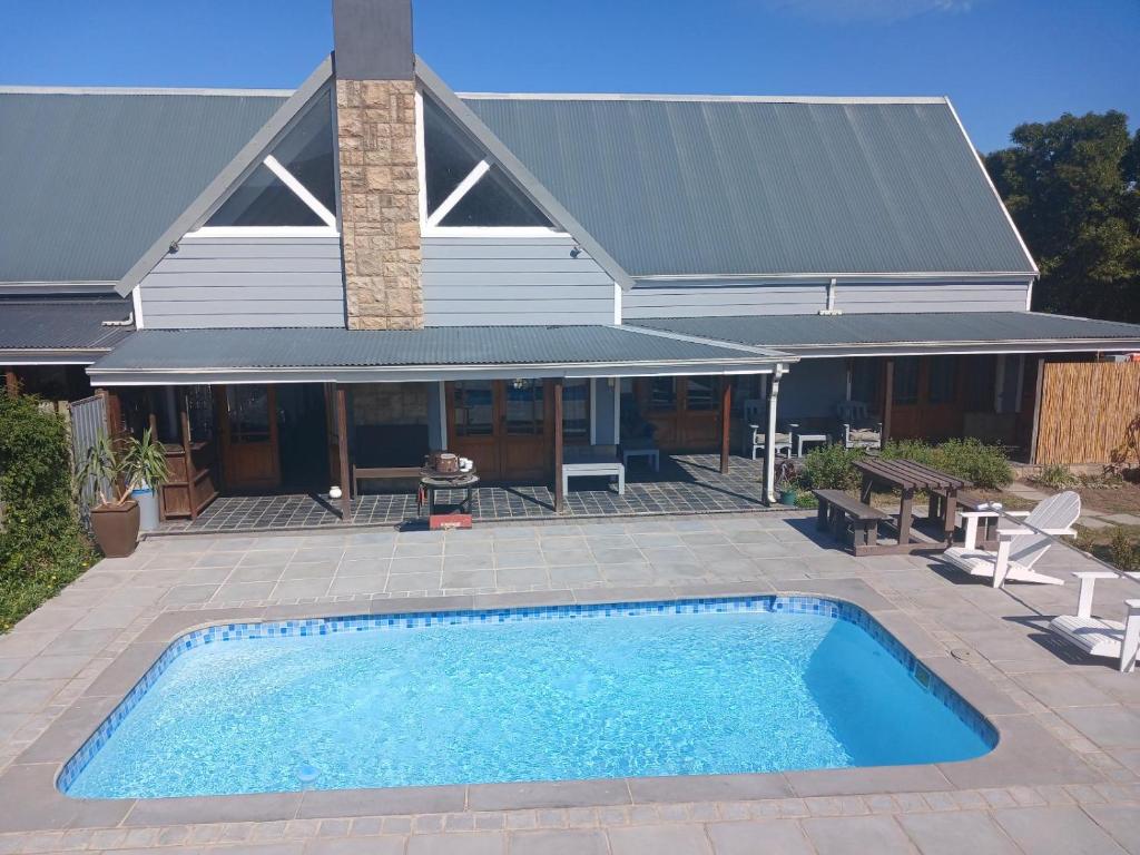 a swimming pool in front of a house at Gables B&B Guesthouse in George