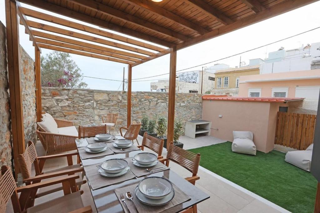 a patio with a table and chairs and a stone wall at VF34 Patio House in Ermoupoli