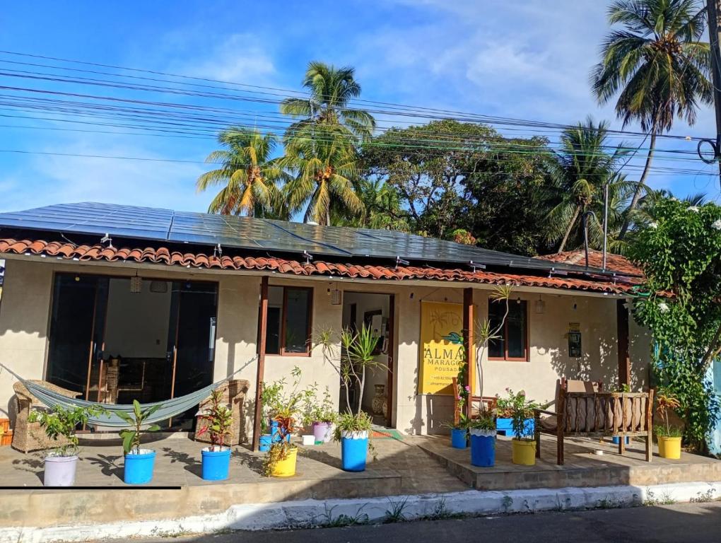 a house with potted plants in front of it at Almar Maragogi in Maragogi