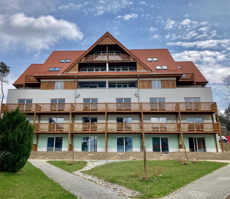 a large white building with a red roof at Apartman Riviera 41 in Lipno nad Vltavou