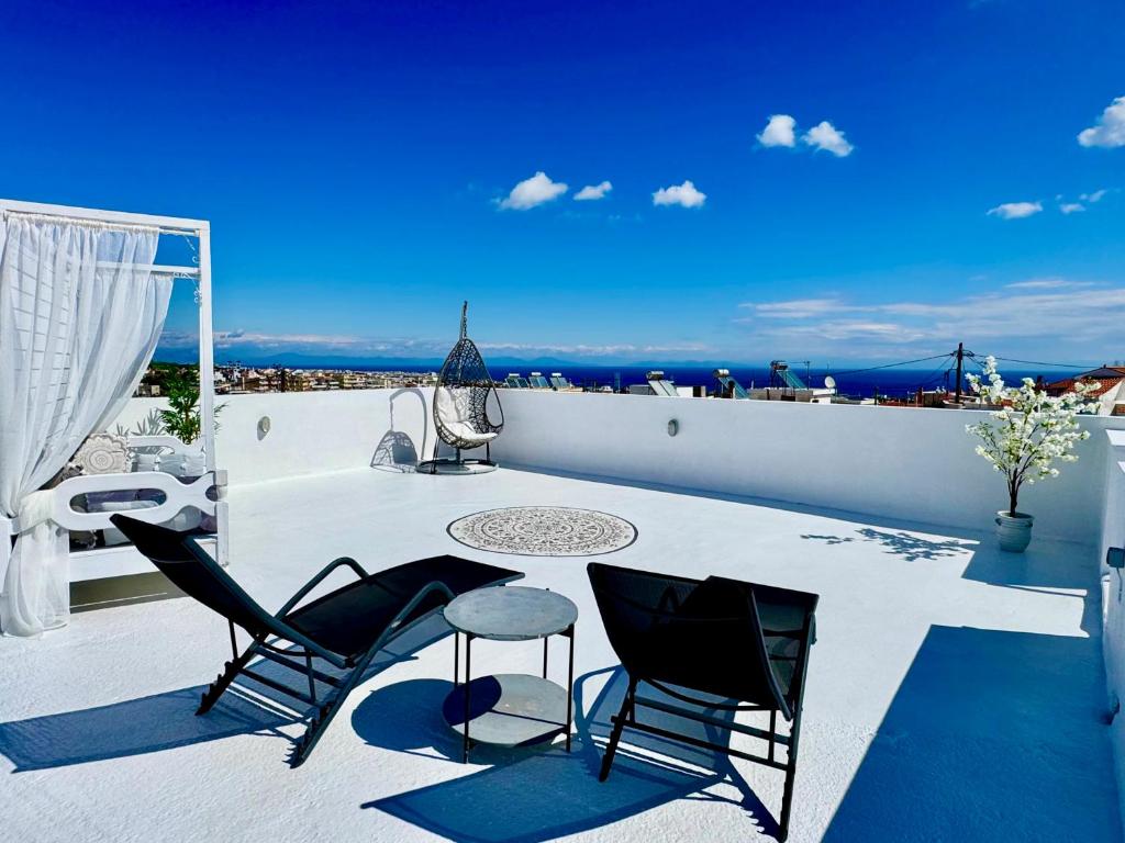 a patio with chairs and a table on a roof at Traditional Villa Sofia in Koskinou