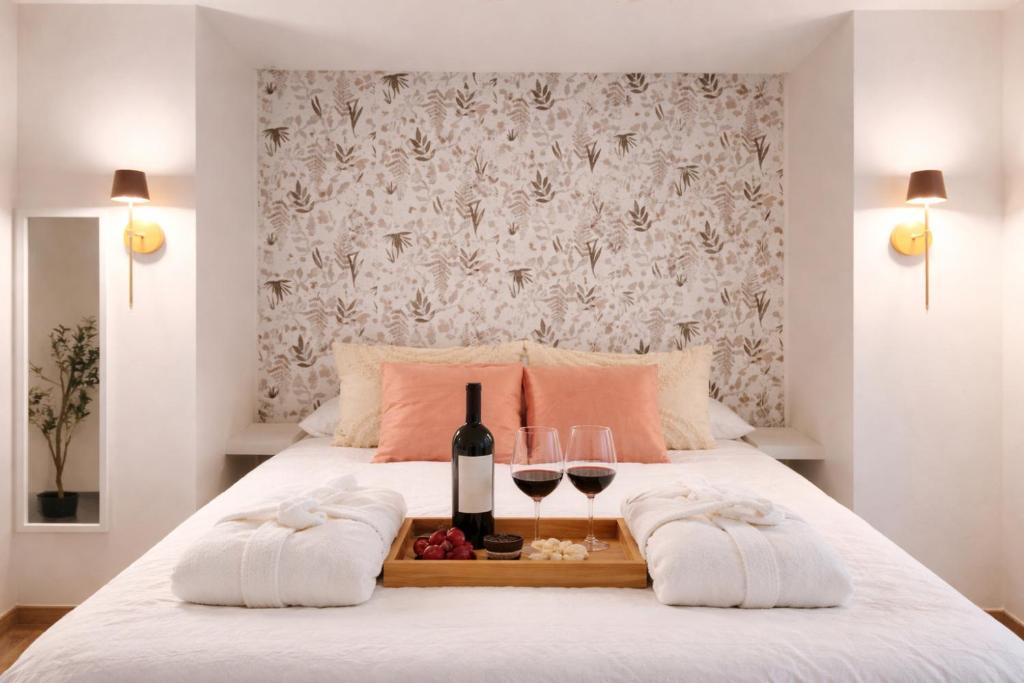 a bed with two glasses of wine and a tray of food at Villa Abril 56 in Oreña
