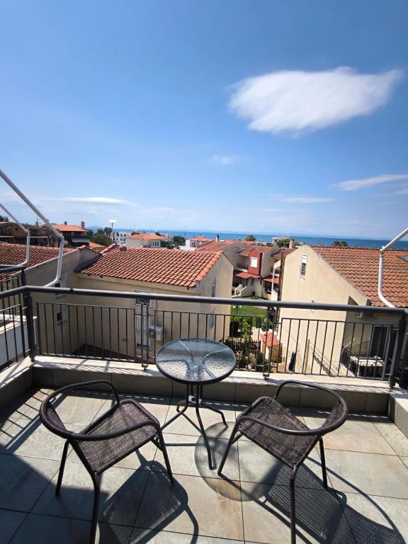 a patio with two chairs and a table on a balcony at Villa Emily in Nikiti