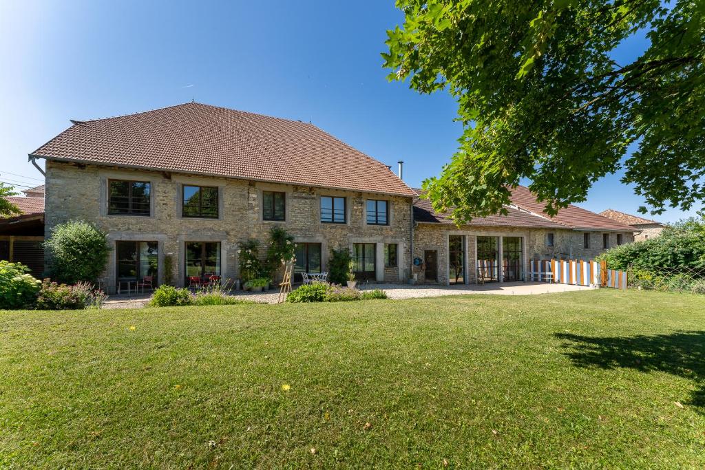 a large brick house with a large yard at Entre Loue et Lison in Amondans