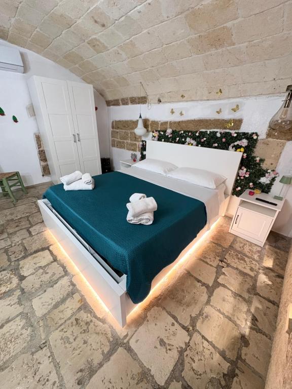 a bedroom with a large bed with a green blanket at Il Cuore di San Cipriano in Mesagne