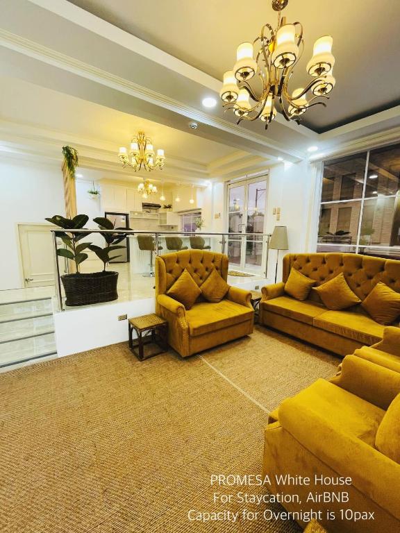 a living room with two couches and a chandelier at Promesa White House in San Fernando
