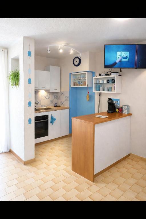 a kitchen with blue and white cabinets and a counter at MES VACANCES A LA MER studio 4 pers, parking privé, wifi, linges fournis, climatisation in La Grande Motte