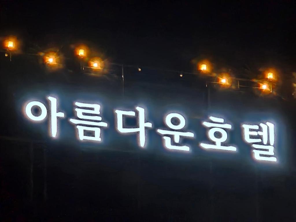 a close up of a lit up clock at night at 아름다운호텔 in T'ongyŏng