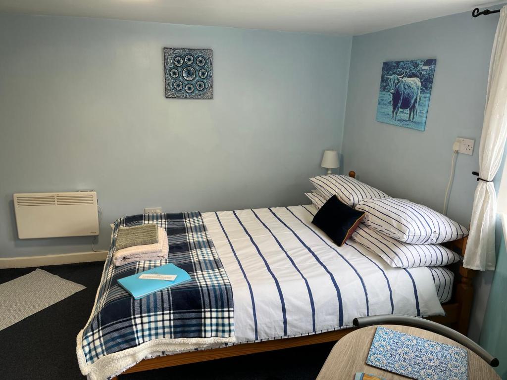 a bedroom with a bed with a striped comforter at The Creamery in Liskeard
