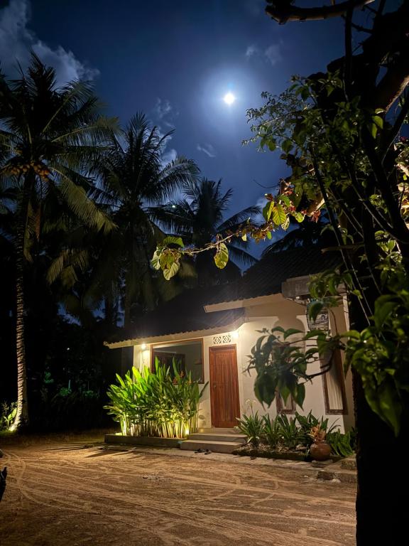 a house at night with the moon in the sky at Kapal Dream Homestay in Selong Belanak