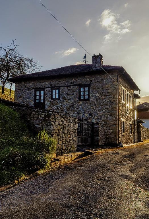 an old stone house on the side of a road at Casa Rosario in Cortina