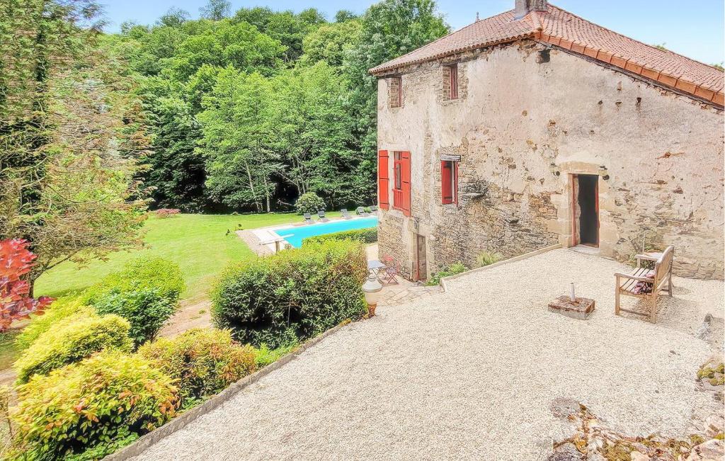 an external view of a stone house with a swimming pool at La Vieille Forge in Sarrazac