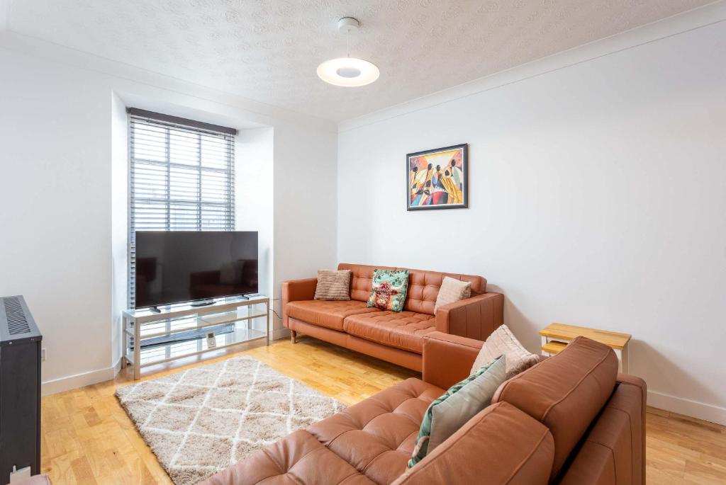a living room with a couch and a flat screen tv at No1 Coppergate - Donnini Apartments in Prestwick