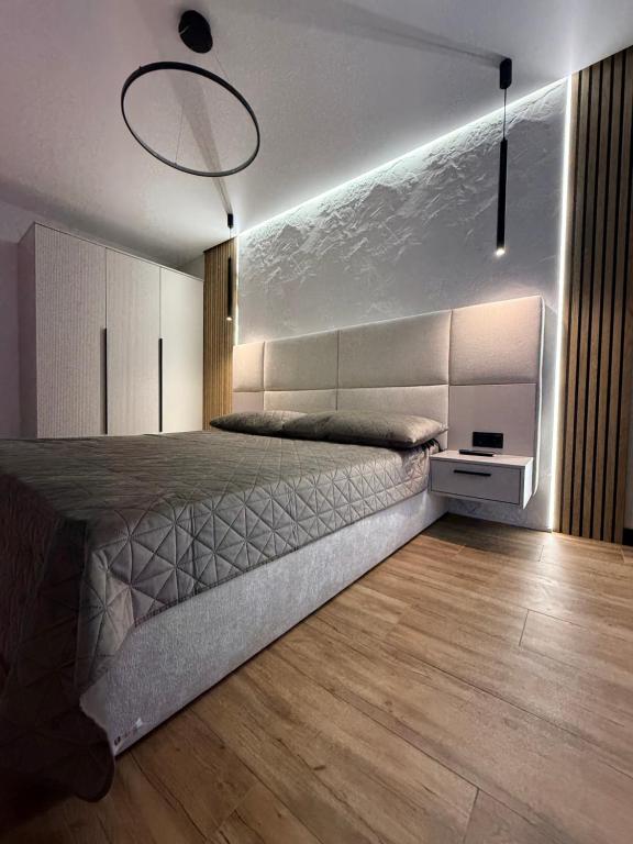 a bedroom with a large bed and wooden floors at Stone & Soul House in Chernihiv