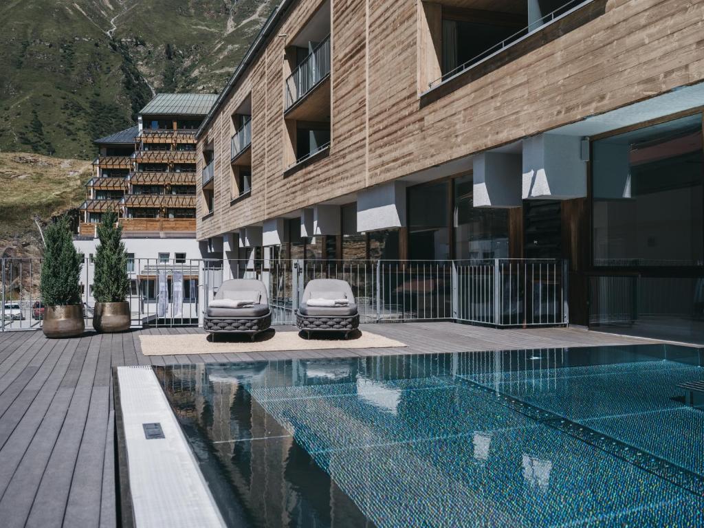 a building with a swimming pool next to a building at The Crystal VAYA Unique in Obergurgl