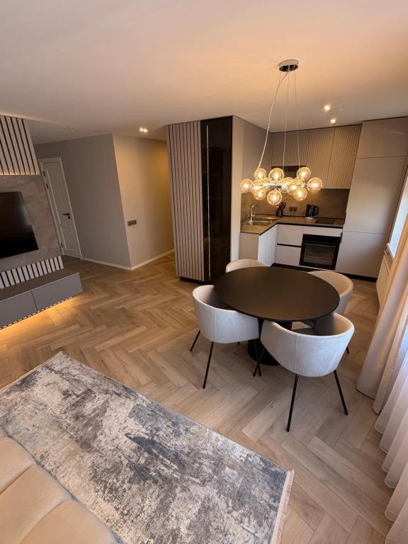 a living room with a table and chairs and a kitchen at JAVA ESTATE apartment in Rēzekne