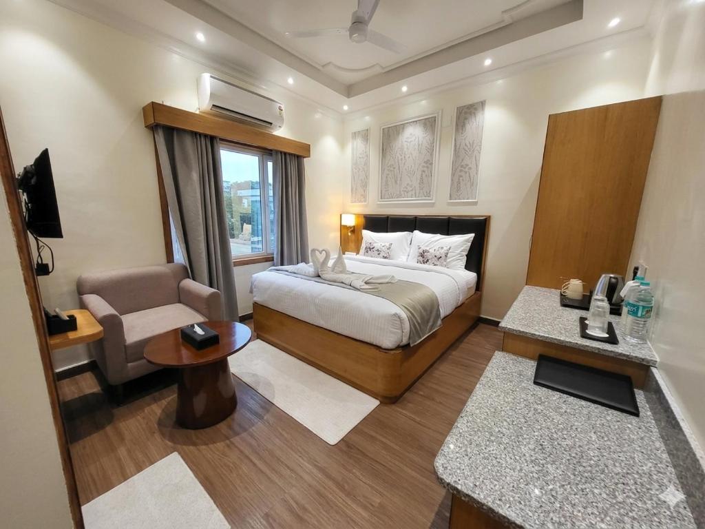 a bedroom with a bed and a chair and a desk at The Park Inn in Jhārsuguda