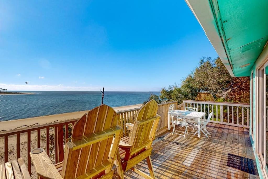 two chairs and a table on a deck overlooking the ocean at Halsell's Hideaway in Indian Pass
