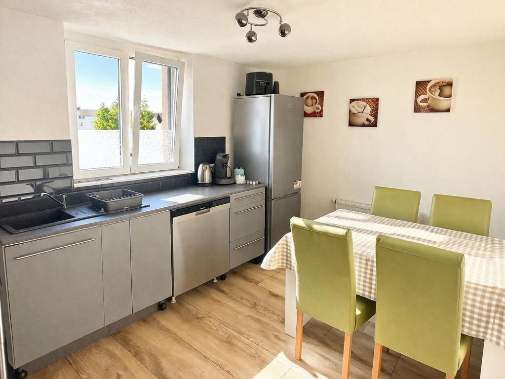 a kitchen with a table and a refrigerator at Ferienwohnung AyNa 3, direkt an der Schweizer Grenze in Bad Säckingen
