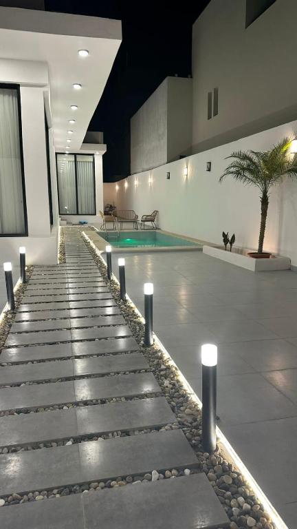 a swimming pool with a palm tree in a building at شاليه بيرلا in Jeddah