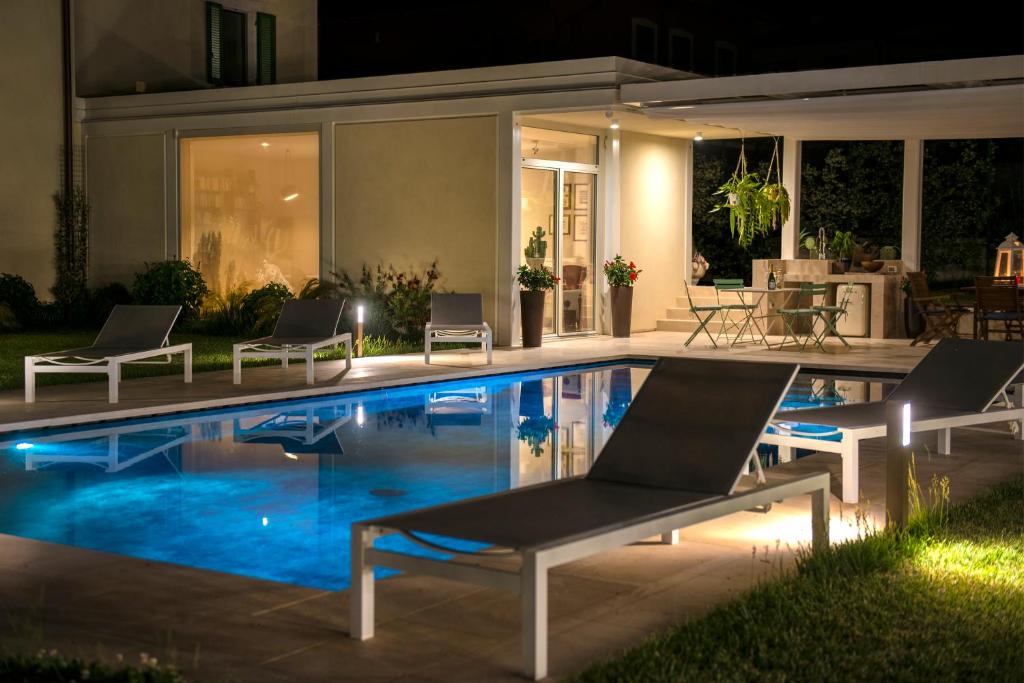 a swimming pool at night with two lounge chairs next to it at GIULIVETO Bed and Breakfast in Foligno