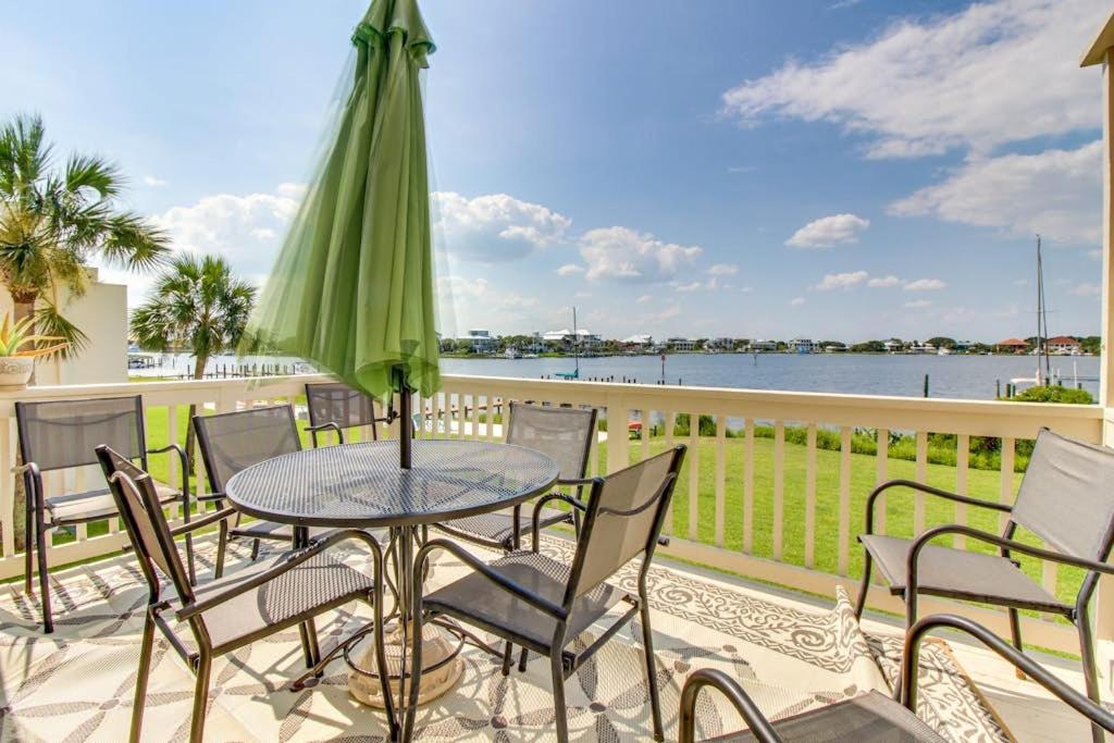 a patio with a table with chairs and an umbrella at The Treehouse On the Bay in Pensacola Beach