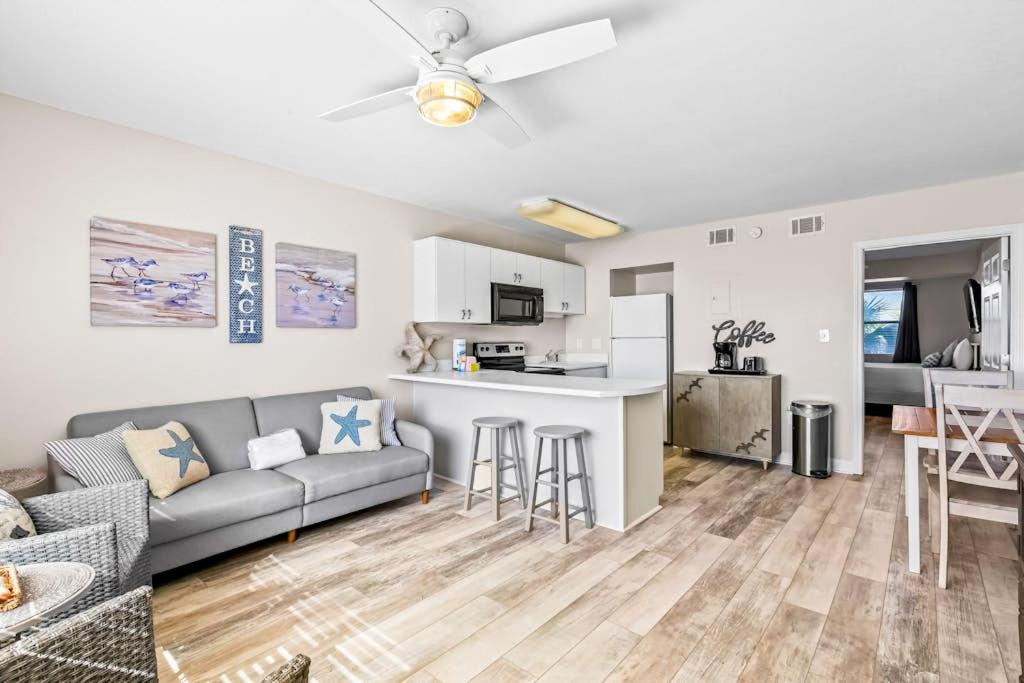 a living room with a couch and a kitchen at Tropical Isle #205 in Fort Walton Beach