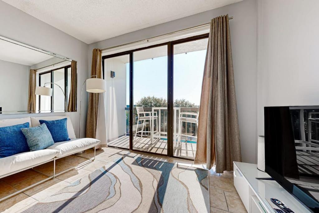a living room with a couch and a large window at Pirates Bay B314 in Fort Walton Beach