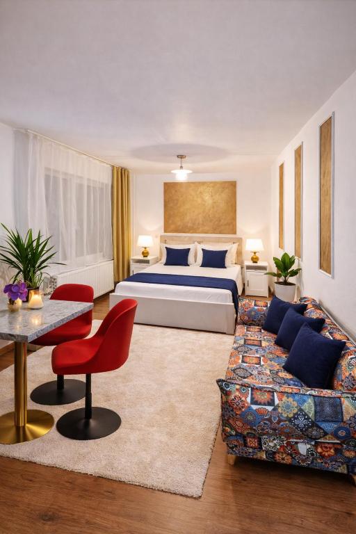 a hotel room with a bed and a couch at Dania&Petru Apartament's in Târgu Ocna