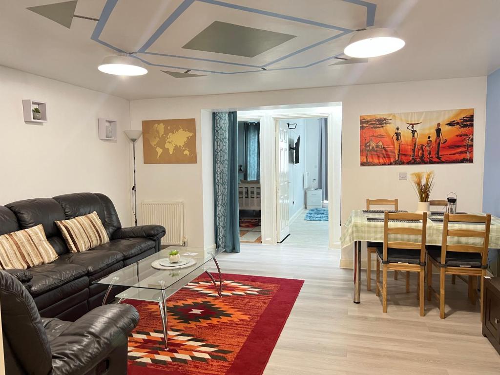 a living room with a couch and a table at Crescent Apartment - Two bedroom in Goodmayes