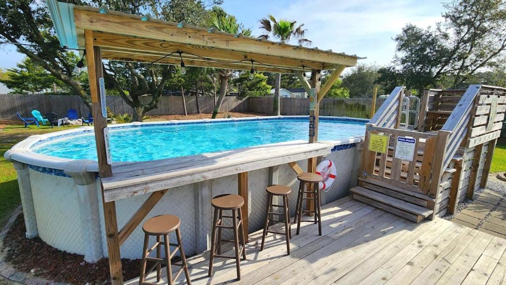 a bar with stools next to a swimming pool at Poolside Palms Paradise in Navarre