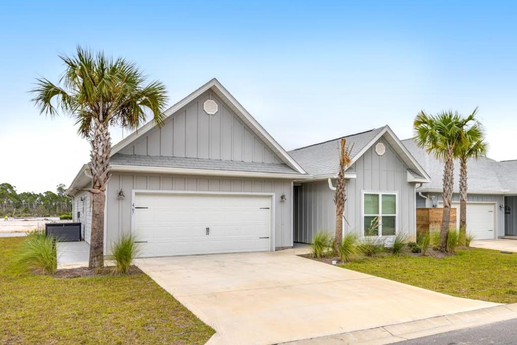 a house with palm trees in front of it at Windmark - Sea Grove Guesthouse in Saint Joe Beach
