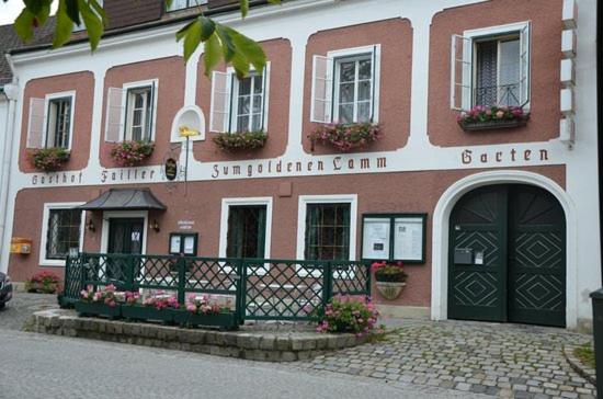 a red and white building with flowers in front of it at Stadthotel Drosendorf - zum Goldenen Lamm - Failler in Drosendorf Altstadt