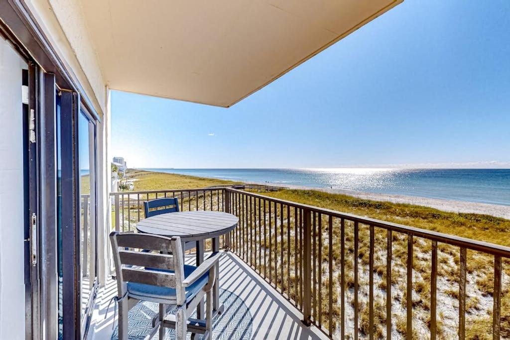 a table and chairs on a balcony with the beach at Sundunes 121 in Navarre