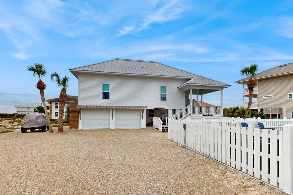 a white fence in front of a house at Sunset & Smiles in St. George Island