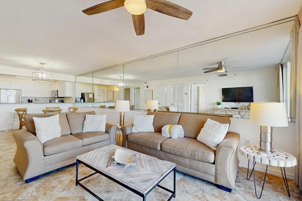 a living room with two couches and a kitchen at Pelican Beach Resort 415 in Destin