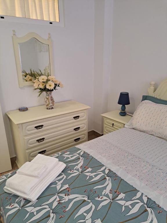 a bedroom with a bed and a dresser with a mirror at Casa da Miquinhas II in Ponte da Barca