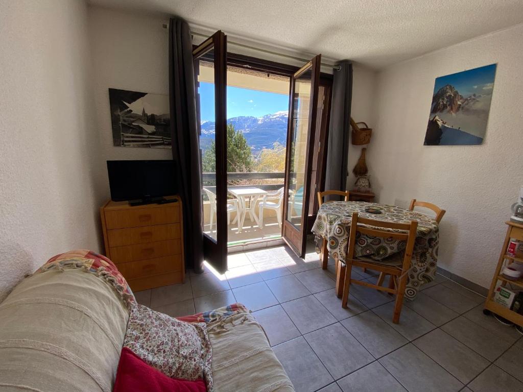 a living room with a view of a balcony at Apartment with stunning mountain views in Barcelonnette