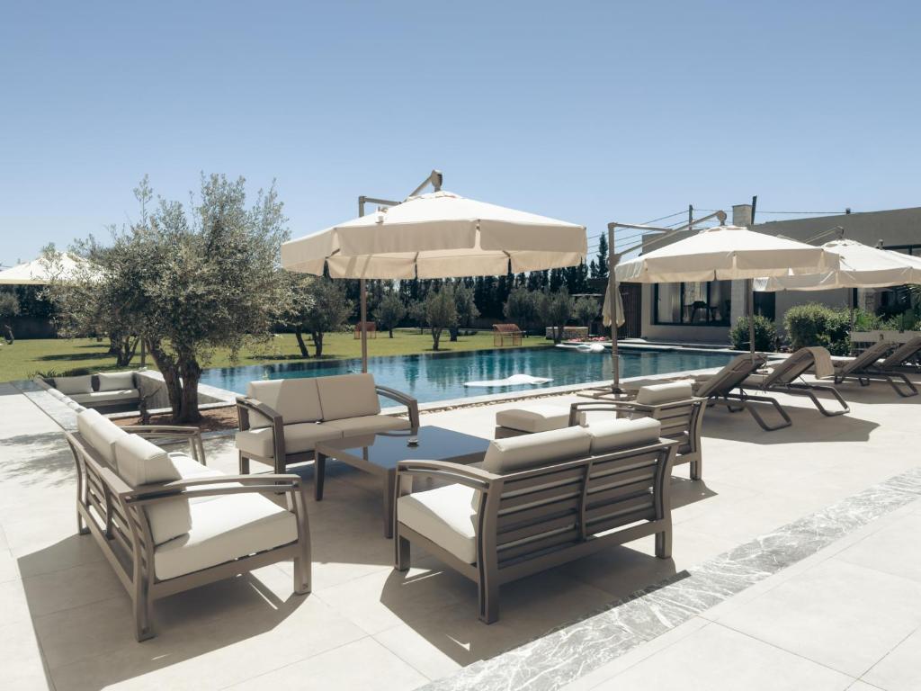 a group of chairs and umbrellas next to a pool at Maison Azen - Moroccan Luxury Stay in Essaouira