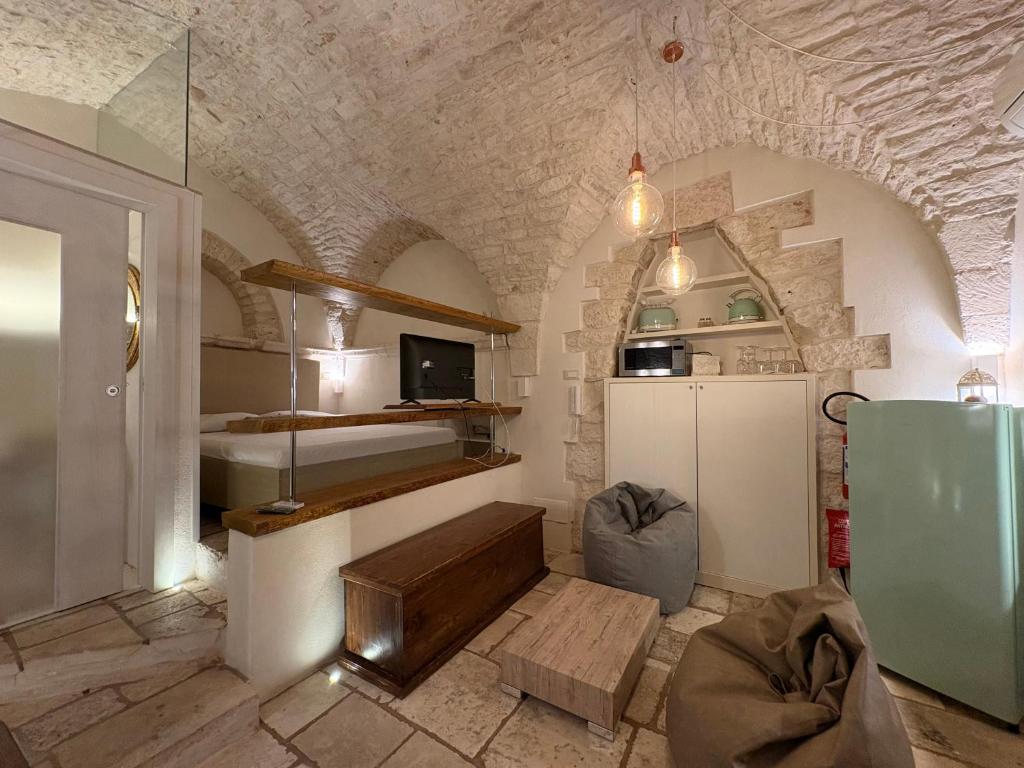 a room with a stone wall and a room with a kitchen at La Piazzetta - Luxury Homes in Ceglie Messapica
