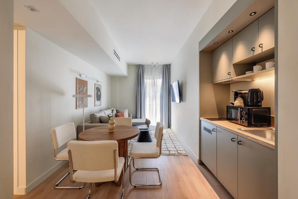 a kitchen and dining room with a table and chairs at Leon by Zoia Living in Piraeus