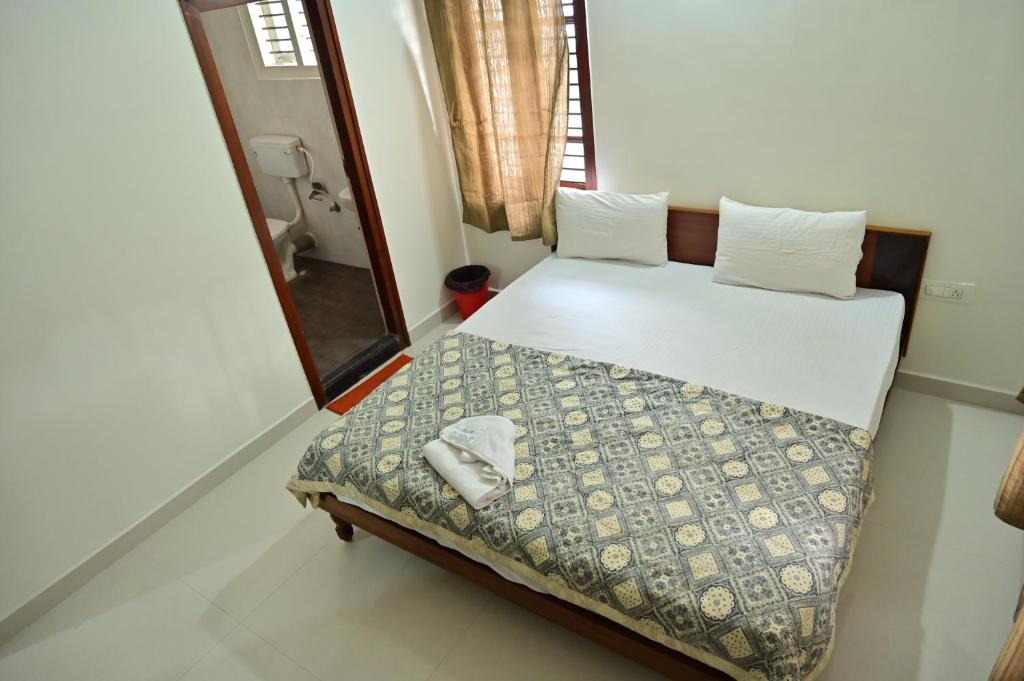a small bedroom with a bed and a mirror at Bn Homestay in Mysore