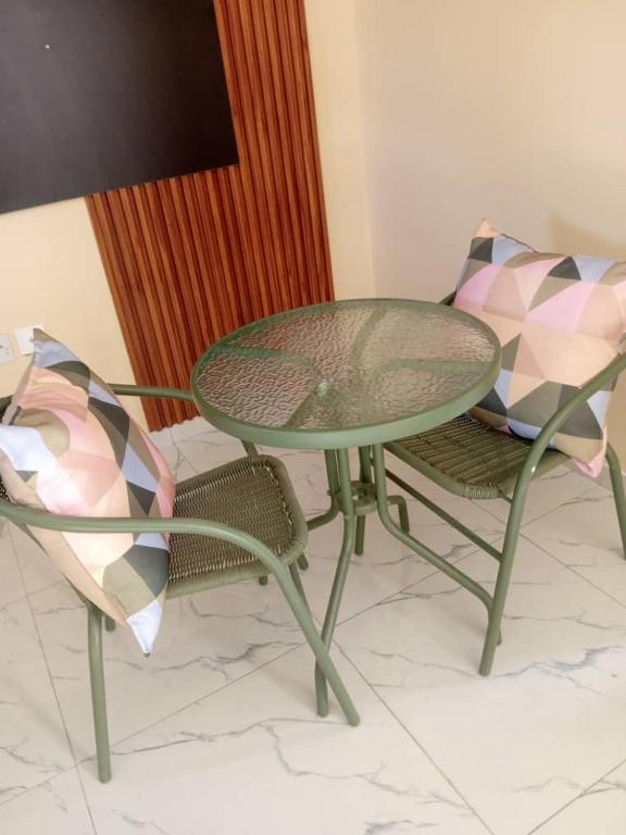 a green table and two chairs and a table and chairs at Sedudu Turn Cottages in Maun