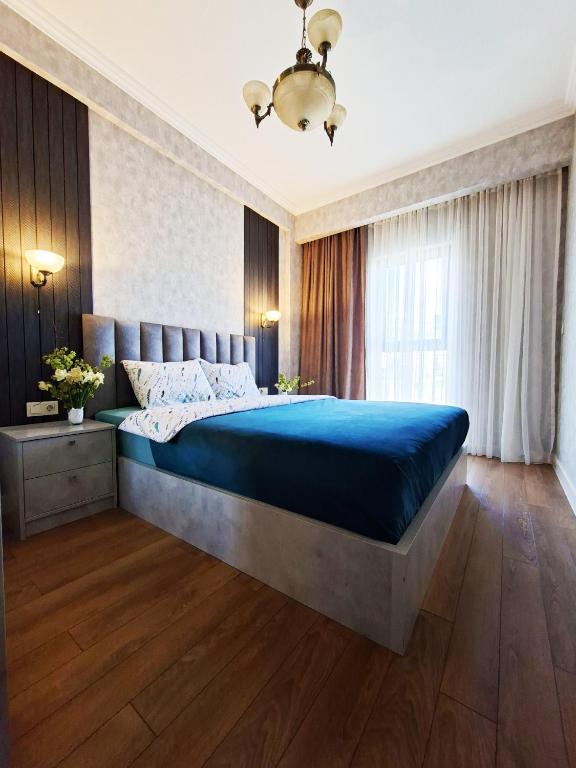 a bedroom with a large bed with a blue comforter at Spacious Riverside Apartment in Central Tbilisi with Balcony in Tbilisi City