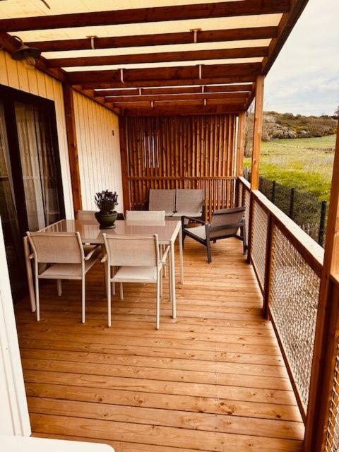 a patio with a table and chairs on a deck at Martinette in Saint-Pair-sur-Mer